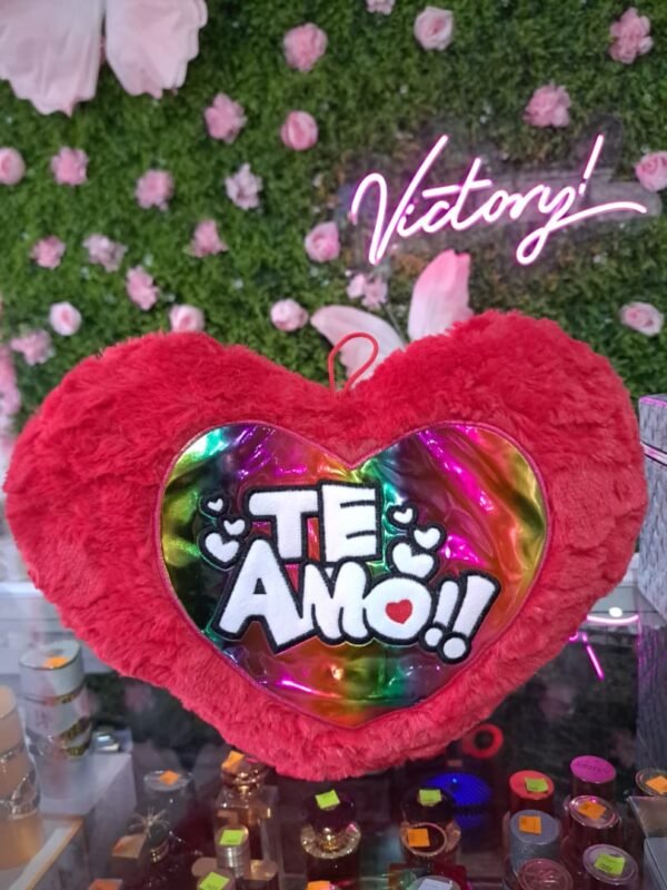 Cojín de peluche en forma de corazón con el texto "TE AMO!!