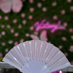 Abanico plegable de tela color rosa con estructura de plástico