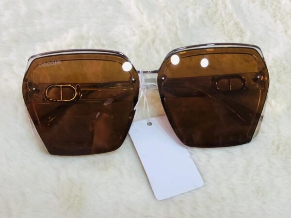 Gafas de sol con lentes cuadradas de color degradado y acentos dorados en la montura.