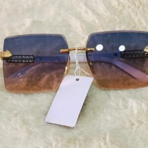 Gafas de sol tipo escudo con cristales degradados y patillas decoradas.