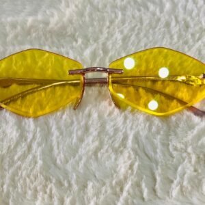 Gafas de sol con diseño hexagonal sin montura y lentes tintadas de color amarillo.