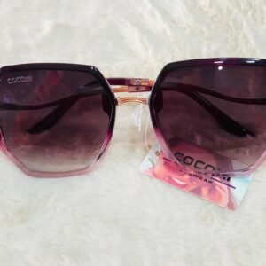 Gafas de sol de la marca Cocom con montura geométrica con cristales degradados en tono púrpura.