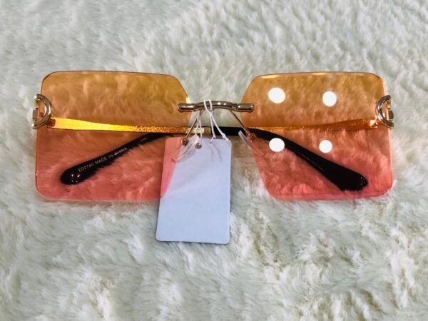 Gafas de sol con diseño rectangular sin montura y lentes con un degradado de naranja a rosa