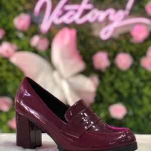 Mocasines de tacón en color vino con acabado de charol alto brillo.