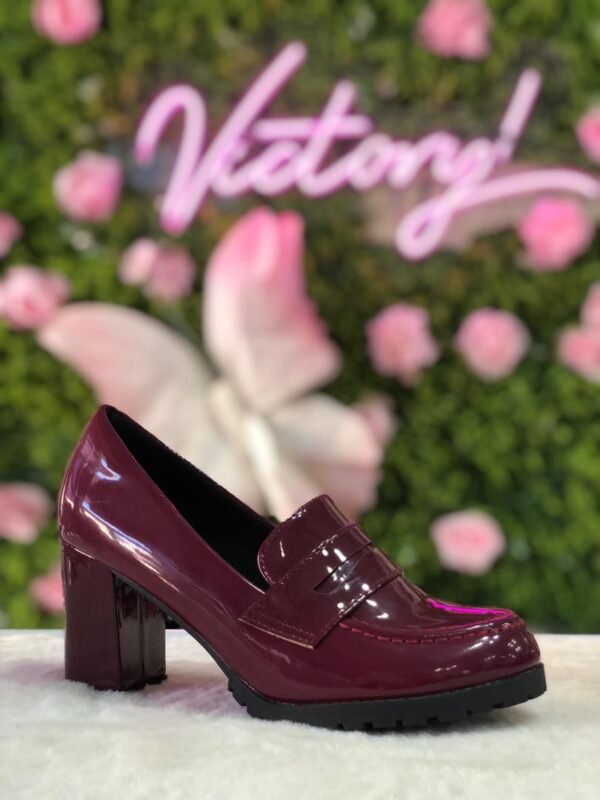 Mocasines de tacón en color vino con acabado de charol alto brillo.