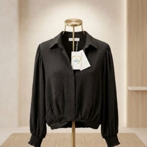 Blusa negra de manga larga con puños elásticos y cuello estilo camisa.