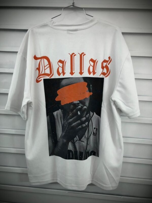 Camisa blanca de estilo urbano con gráfico impreso de una persona fumando y la palabra "Dallas"
