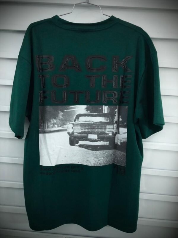 Camisa con gráfico en la espalda con el logotipo de "Back to the Future" sobre una imagen de un automóvil, ofreciendo un estilo casual y nostálgico.