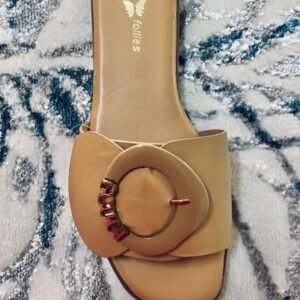Sandalias planas de mujer de la marca Follies, decoradas con una hebilla grande en el frente.