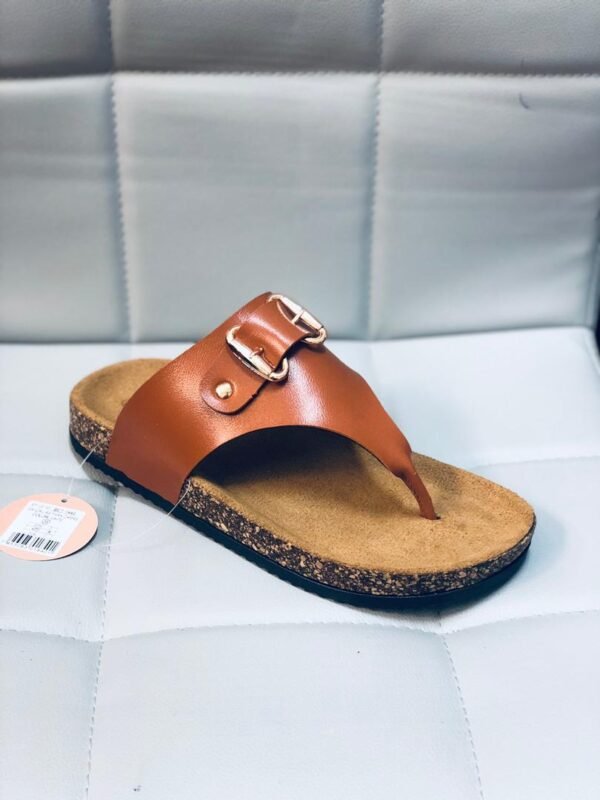 Sandalia de estilo casual con suela tipo corcho y una banda superior con hebilla decorativa.