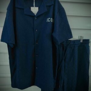 Conjunto de ropa para hombre consta de una camisa de manga corta y pantalones cortos a juego en color azul oscuro, ambos con la palabra "ICON" impresa