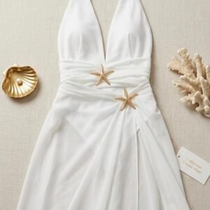 Vestido blanco de playa tipo pareo o salida de baño con detalles de estrellas de mar decorativas.