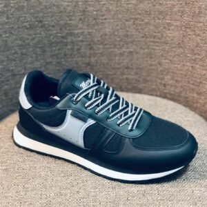 Zapatos deportivos para hombre presentan una combinación de colores negro y gris con cordones blancos.