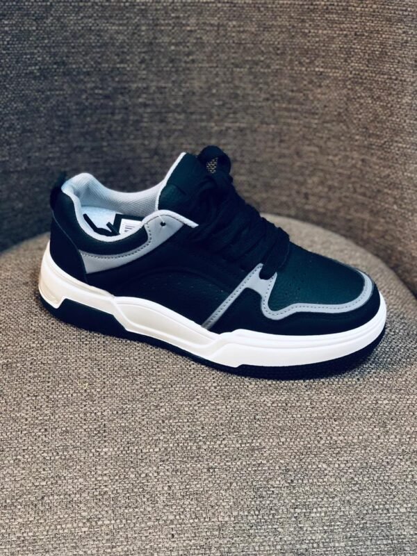 Tenis casuales de color negro y blanco con un diseño moderno.