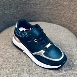 Zapatos deportivos para niños con diseño elegante con colores negro y dorado.