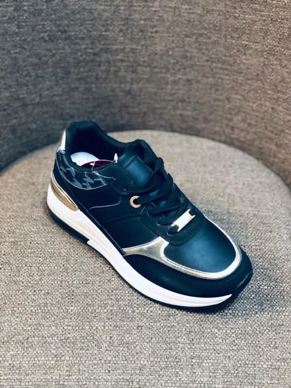 Zapatos deportivos para niños con diseño elegante con colores negro y dorado.