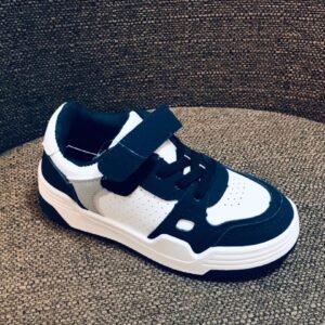 Zapatillas deportivas de bebé/niño en color blanco y negro, estilo casual con cierre de velcro.