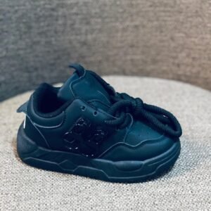 Zapatillas deportivas infantiles de color negro con un diseño grueso y plataforma.