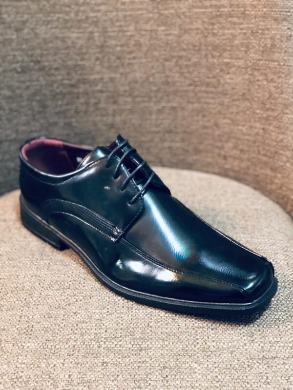 Zapato de vestir para hombre con acabado brillante y diseño clásico de punta cuadrada.