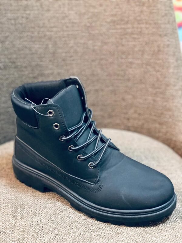 Bota de hombre de color negro, diseñada con un estilo tipo work boot y cordones.