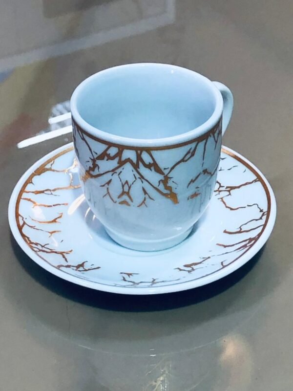Juego de 6 tazas con plato con un diseño blanco y detalles dorados tipo mármol o ramificaciones.