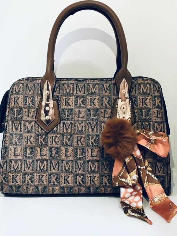 Bolso de mano con estampado de monograma "MM", asas de cuero marrón y un accesorio colgante decorativo de borla y pañuelo.