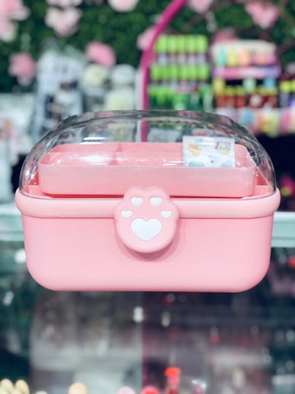 Caja organizadora de color rosa con tapa transparente, ideal para guardar accesorios de cabello, maquillaje o artículos de papelería.