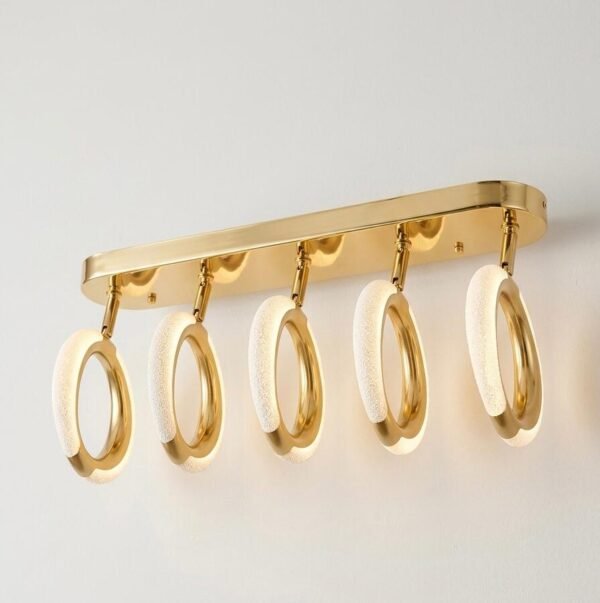 Lámpara de pared decorativa con cinco focos LED ajustables montados sobre una base dorada, ideal para iluminación de interiores.