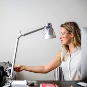 Woman in modern office setting using printer, blending technology with contemporary style.