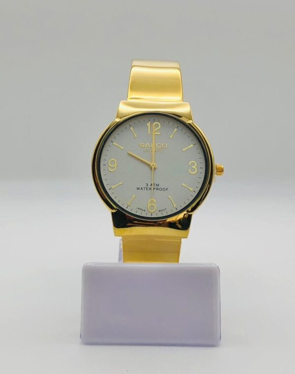 Reloj de pulsera dorado marca Salco con movimiento de cuarzo japonés y esfera blanca.