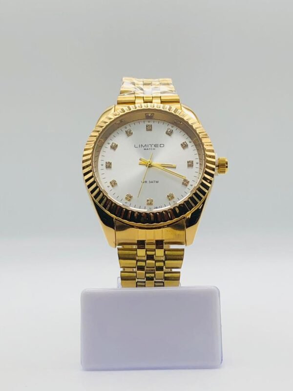 Reloj Limited de cuarzo en tono dorado con esfera plateada y marcadores de hora de cristal.